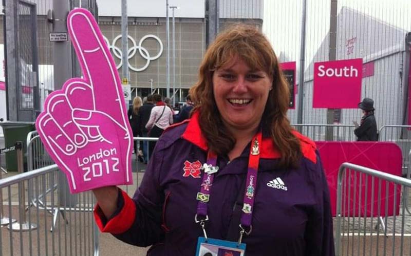 a woman holding a pink glove at the London Olympics