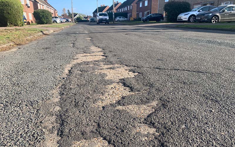 a broken road surface in Bellfield Avenue, Brightlingsea